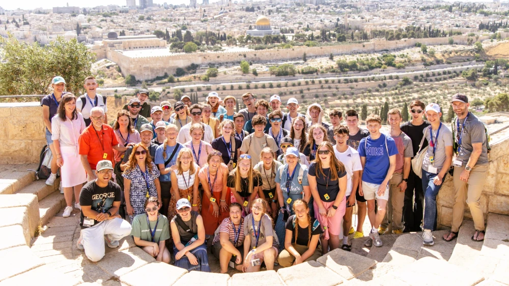 Students on the Passages summer trip 2026 delegation to Israel stop for a group photo overlooking Jerusalem. Photo by Caroline Logan.