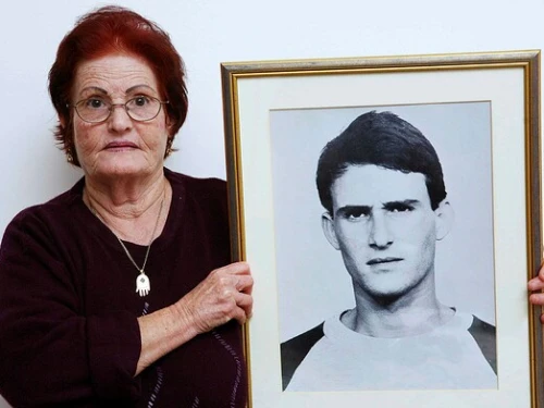 Galia Tamam holds a picture of her son, Moshe, who was murdered by Palestinian terrorists in 1984. Photo by Yehoshua Yosef.