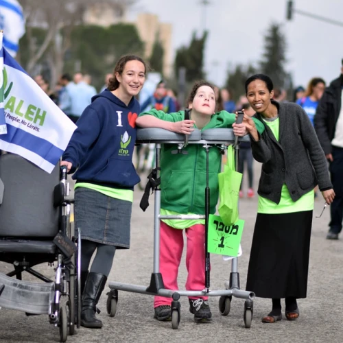 Volunteers and their young charge at a march for ALEH, Israel’s network of care for children with severe complex disabilities. Credit: Courtesy.