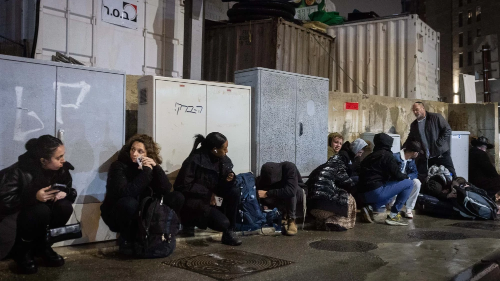 People take cover in Jerusalem as sirens warn of incoming missile fire from Yemen, March 20, 2025. Photo by Chaim Goldberg/Flash90.