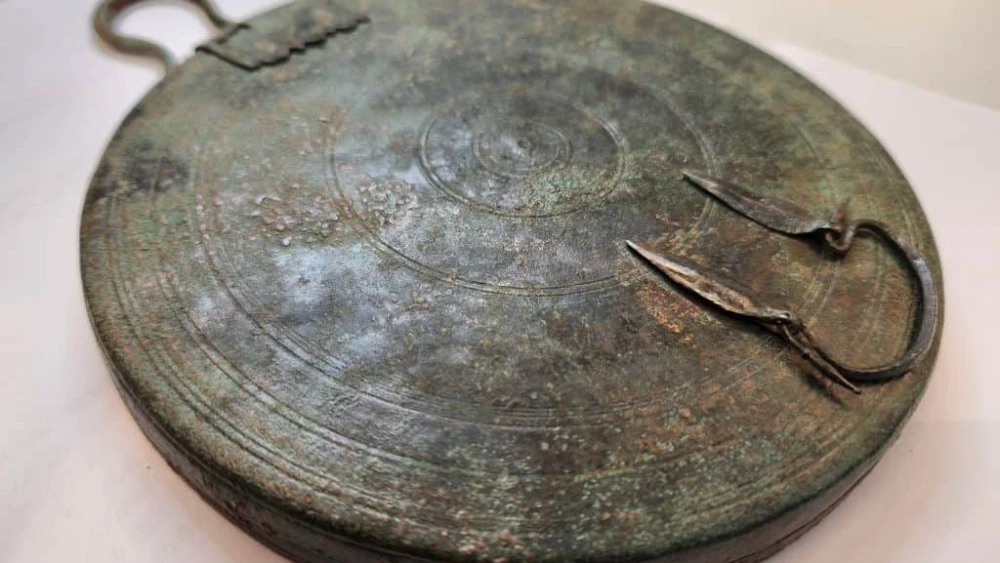 The ancient bronze folding mirror found in a Jerusalem tomb. Photo by Yoli Schwartz/Israel Antiquities Authority.