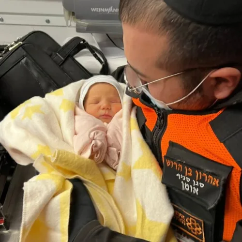 Aharon ben-Harush, deputy commander of United Hatzalah’s relief mission to the Ukrainian-Moldovan border, in an ambulance with one of the Israeli newborns he helped rescue from war-torn Kyiv. Photo courtesy of United Hatzalah.