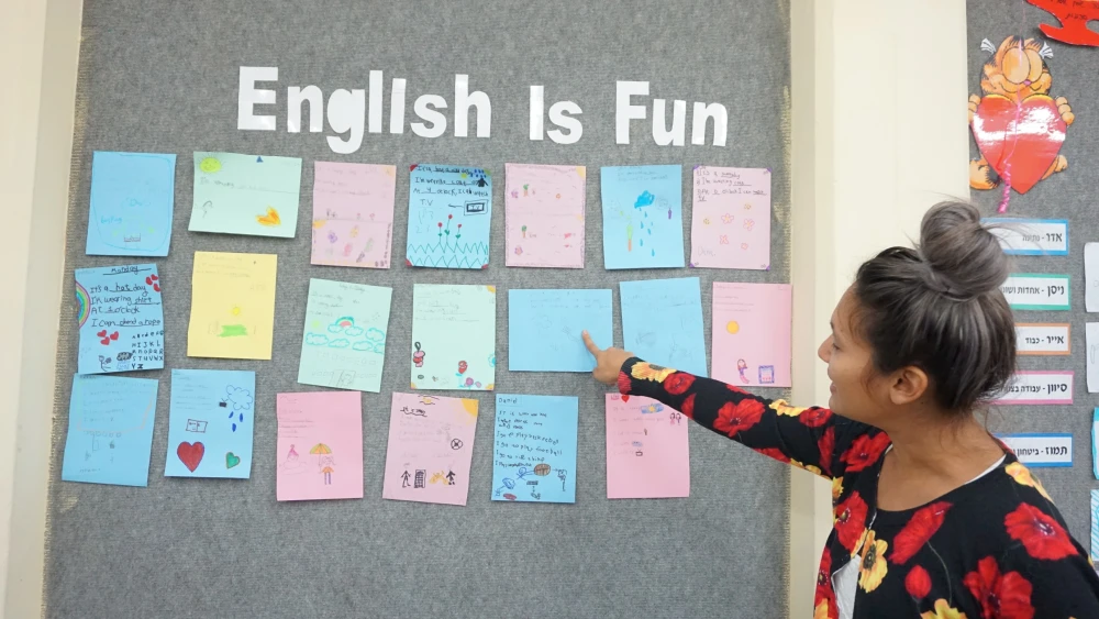 A Masa Israel Teaching Fellow examines artwork from Israeli students. Credit: Masa Israel Journey.