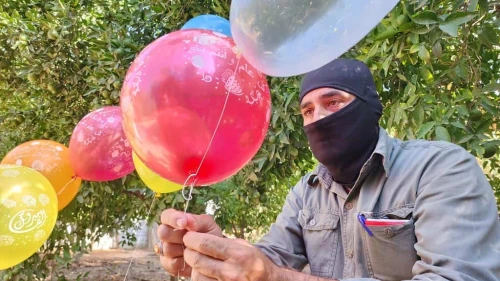 Masked terrorists prepare helium balloons with incendiary material to be flown into Israel, aiming to cause casualties and damage, on Sep. 22, 2023. Photo by Majdi Fathi/TPS.