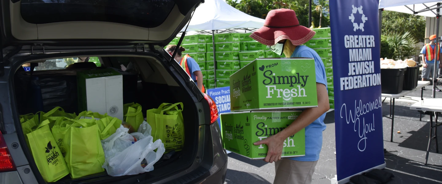 Volunteers hand out food at a kosher drive-by distribution site sponsored by the Greater Miami Jewish Federation, Feeding South Florida, Jewish Community Services of South Florida and Temple Emanuel in July. Credit: Courtesy.