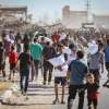 Palestinians carrying bags of flour outside a distribution site run by the Gaza Humanitarian Foundation in Deir al-Balah, the central Gaza Strip, on May 28, 2025. Photo by Ali Hassan/Flash90.