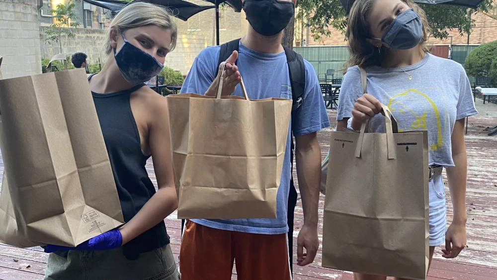 Students participate in “Shabbat-to-Go” meal pickup on the Texas Hillel patio in the fall of 2020. Credit: Courtesy.