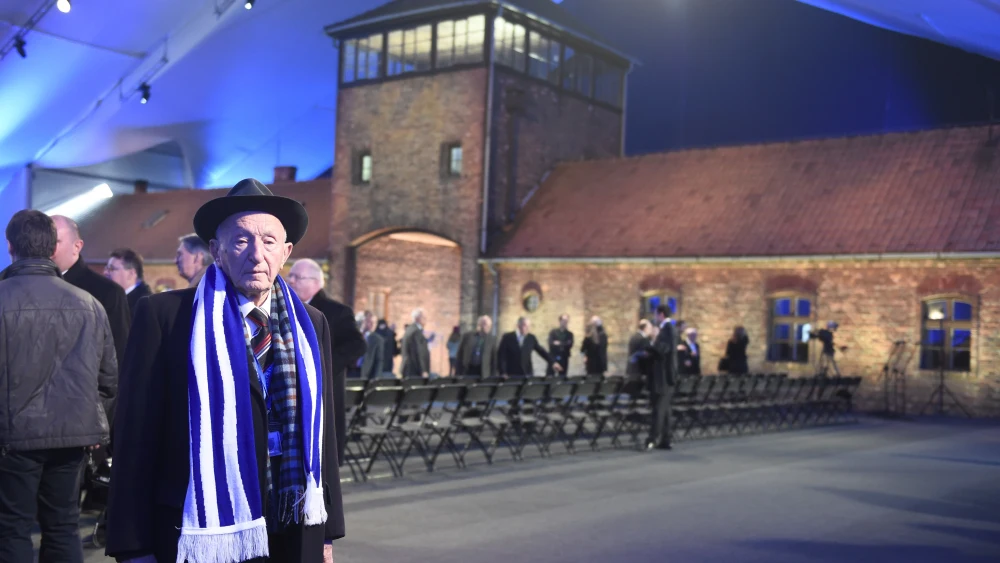 Israel’s oldest Holocaust survivor at the entrance of the former Nazi concentration camp Auschwitz-Birkenau in Poland