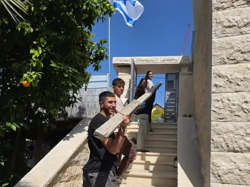 Volunteers assist residents of Beit Shemesh impacted by the March 1 Iranian ballistic missile attack on the city, March 12, 2026. Credit: Shir Goren.