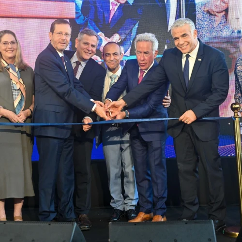 Israeli-Canadian businessman Sylvan Adams (third from right) cuts the ribbon to inaugurate the Sylvan Adams Emergency Hospital along with Israeli Prime Minister Yair Lapid (second from right) and Israeli President Isaac Herzog (third from left), together with other dignitaries, July 28, 2022. Credit: Jenny Yerushalmi.