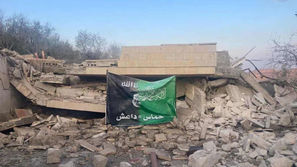 The Hamas-ISIS flag placed by Israeli troops on the ruins of the Samaria home of Hamas leader Saleh al-Arouri. Source: Twitter.
