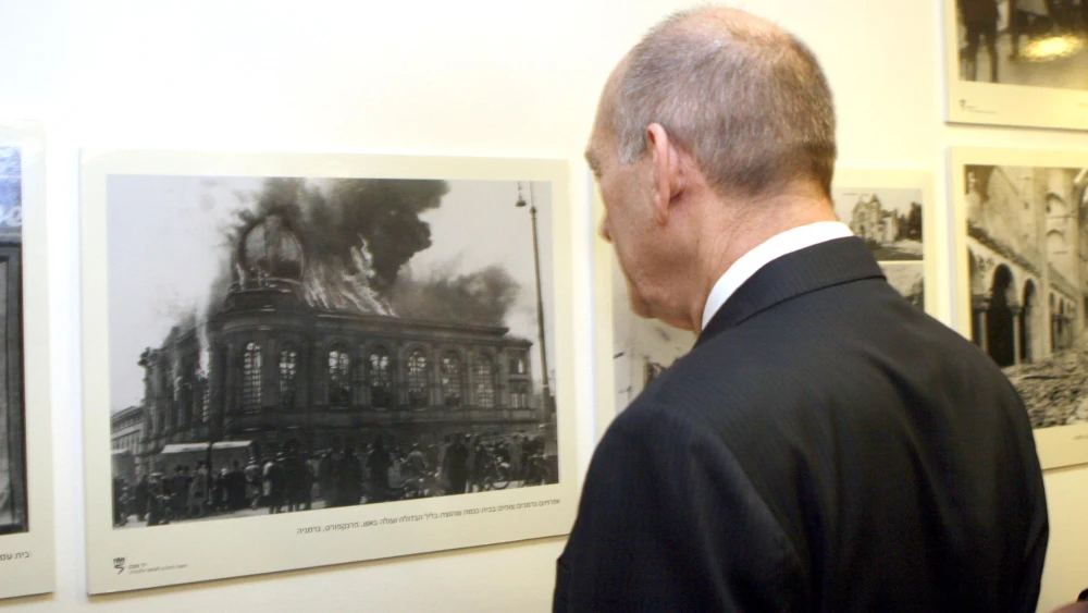 Ten years ago at the 70th commemoration of Kristallnacht, Israeli Prime Minister Ehud Olmert looks at a photo exhibition of horrific images that were taken on the night of Nov.9-10, 1938. Photo by Ariel Jerozolimski/Flash90.