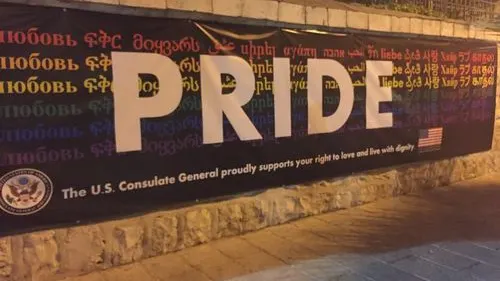 Click photo to download. Caption: During Jerusalem's 2016 gay pride parade, a sign at the American Consulate General reads, “The U.S. Consulate General proudly supports your right to love and live with dignity.” Credit: Eliana Rudee.