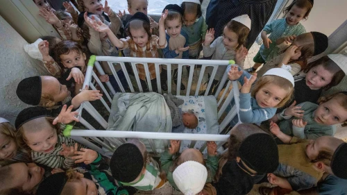 Boys in Jerusalem's ultra-Orthodox neighborhood of Mea She'arim recite the "Shema Yisrael" prayer in the presence of a week-old baby, a day before his circumcision ceremony, July 9, 2023. Photo by Chaim Goldberg/Flash90.