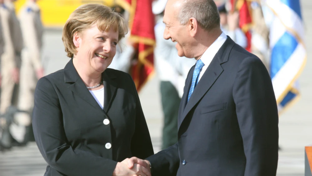 German Chancellor and European Union president Angela Merkel and Israeli Prime Minister Ehud Olmert attend a welcoming ceremony March 16, 2008, at Ben-Gurion International Airport. Credit: Yossi Zamir/Flash90.