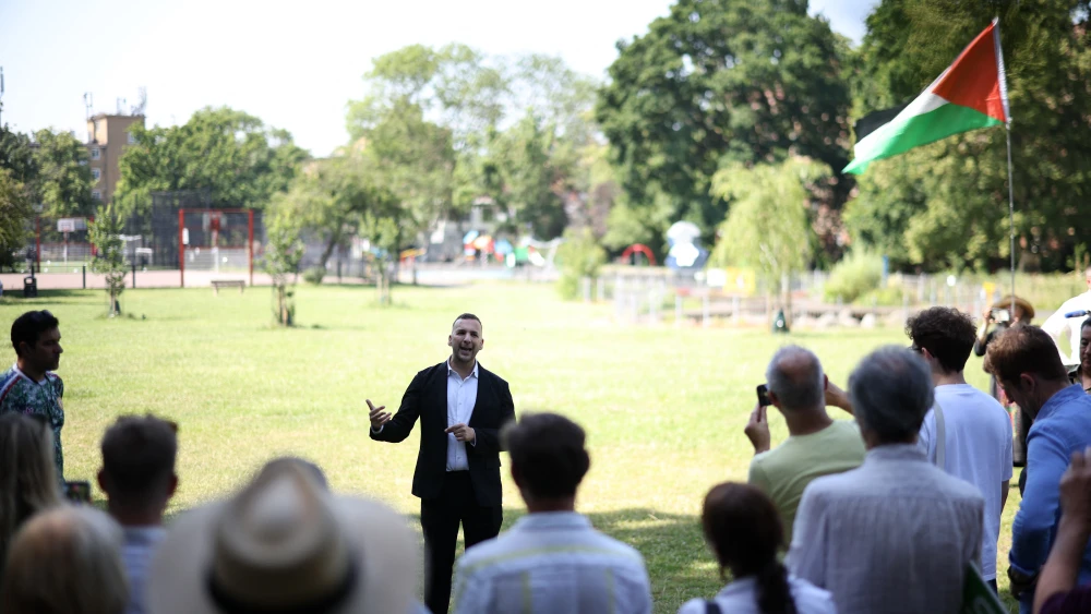Zack Polanski, the leader of the British Green Party, stands in the shade of a tree in a park as he addresses supporters during a rally in London on June 24, 2026.