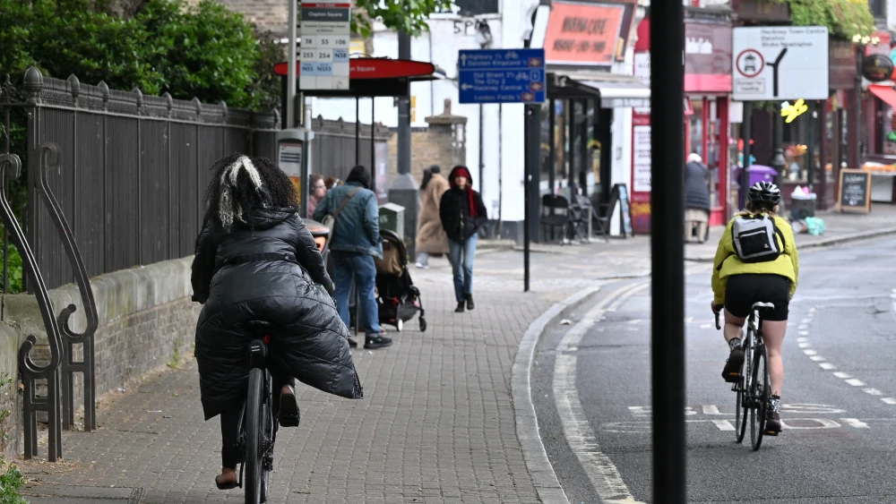 A cyclist rides on the road while another rides on the pavement along the Lower Clapton Road in the London Borough of Hackney on May 11, 2026 in London, England. Photo by John Keeble/Getty Images.