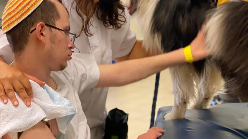 Netanel Felber with Dr. Adi Gidali and Sheba, a physiotherapy dog. Credit: Sheba Medical Center.
