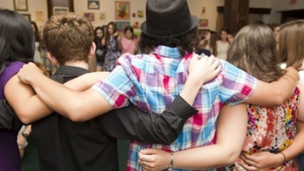Community singing in a circle at the Passport NYC Jewish camp in New York City. Jewish summer camp is all about the networking, writes JNS.org humor columnist Leo Margul. Credit: Andrew Sherman/92Y Passport NYC.