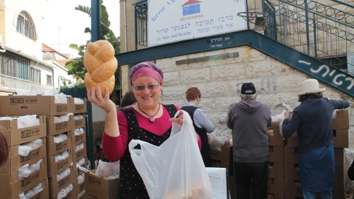Volunteer Rita Lewy displays a loaf of challah at the Terror Victims Support Center. Credit: Courtesy.