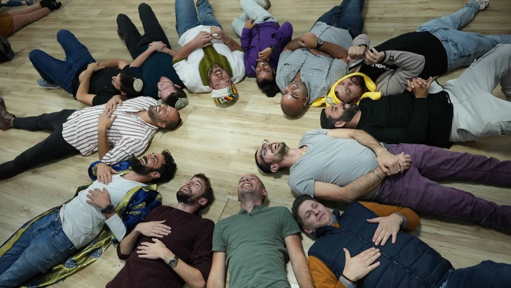 A "laughter circle" at a workshop of bereaved young adult siblings that took place at the OneFamily headquarters in Jerusalem. Photo by Meir Pavlovsky.