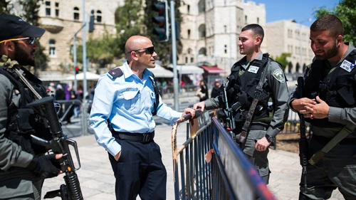 Click photo to download. Caption: An Israeli policeman (second from left) speaks to Israeli soldiers guarding the stairs to the Damascus Gate in Jerusalem's Old City on March 23, 2016. Credit: Corinna Kern/Flash90.