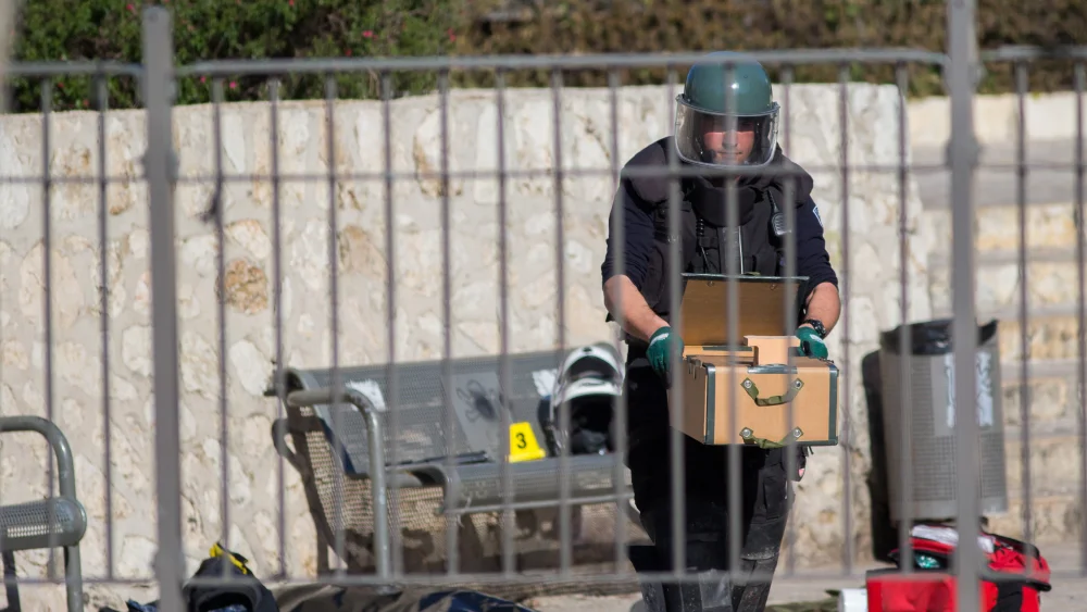 An Israeli Police sapper carries an explosive device at the scene of a shooting and stabbing attack near Damascus Gate, Jerusalem, Feb. 3, 2016. Photo by Yonatan Sindel/Flash90.