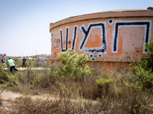 Visitors walk by the water tower in the ruins of the former community of Homesh, Aug. 27, 2019. Photo by Hillel Maeir/Flash90.