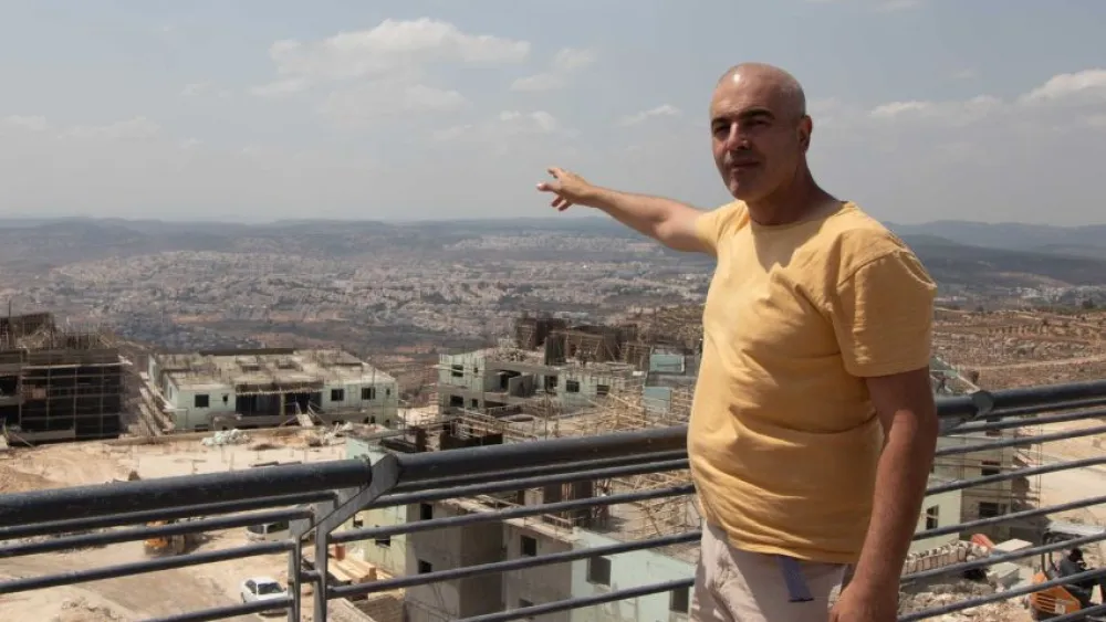Michael Sperber points to an area to the east from a lookout point near the Israeli settlement of Neve Daniel, Aug. 10, 2022. Photo by David Isaac.
