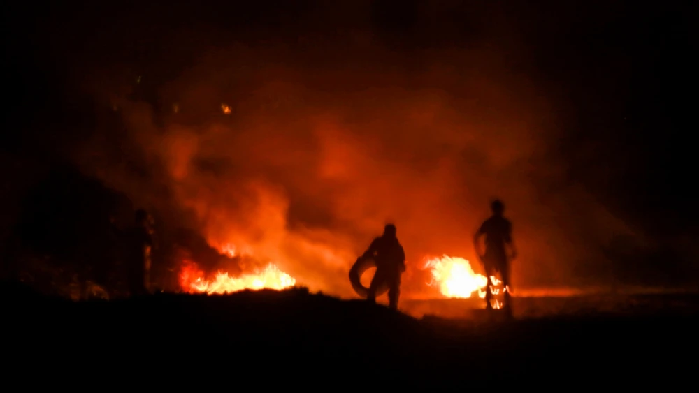 Palestinian protesters burn tires during a night protest near the border with Israel in the southern Gaza Strip, Feb. 14, 2019. Photo by Abed Rahim Khatib/Flash90.
