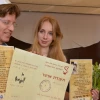 Boaz Bau-Simon, the grandson of Joseph and Rebecca Bau, with his fiancé Or (Irena) Gatina in February 2014. The couple announced its engagement at the ceremony commemorating the 70th wedding anniversary of Bau-Simon's grandparents. Bau-Simon and Gatina are pictured holding a "teudat osher" ("certificate of happiness") originally created by Joseph Bau as well as a letter relating the story of the lifelong romance of Joseph and Rebecca Bau. Credit: Maxine Dovere.