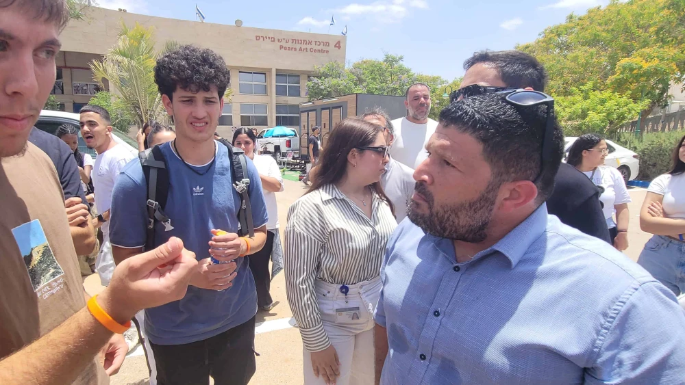 El entonces diputado Almog Cohen (derecha) habla con manifestantes que protestaban contra Yair Golan en una conferencia en Beersheba, el 27 de mayo de 2025. Foto: Canaan Lidor.