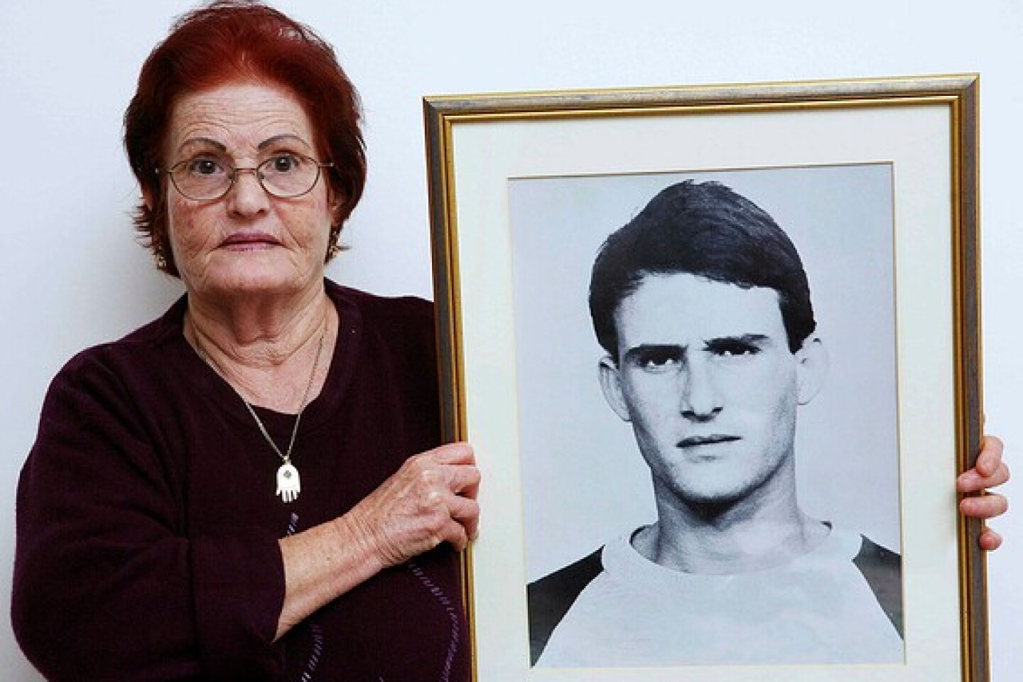 Galia Tamam holds a picture of her son, Moshe, who was murdered by Palestinian terrorists in 1984. Photo by Yehoshua Yosef.
