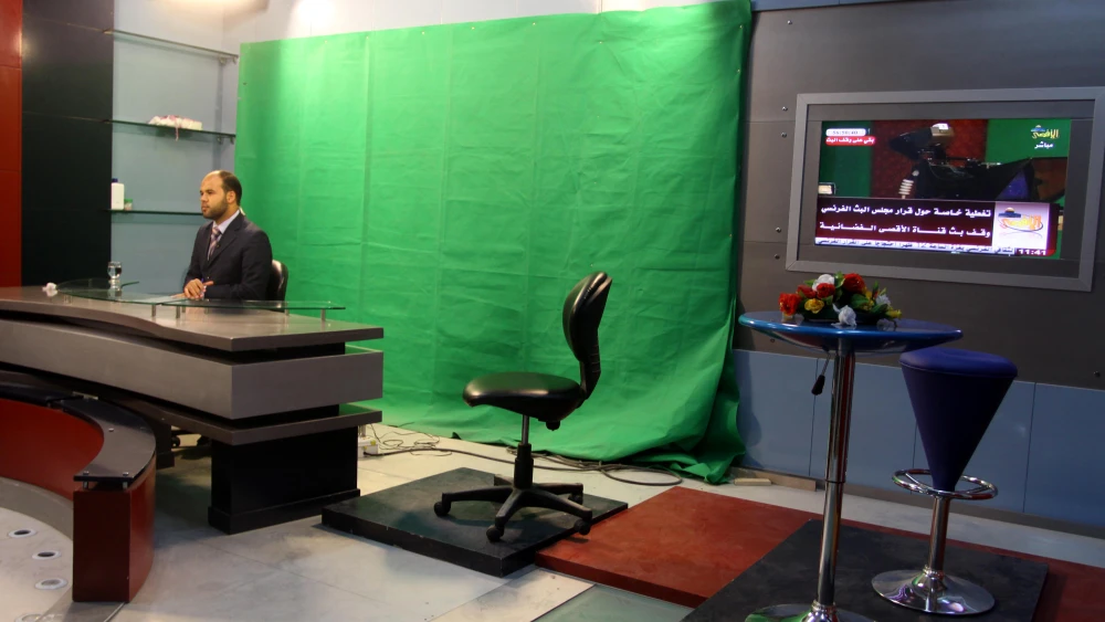A Palestinian broadcaster presents a newscast at the Hamas Al-Aqsa TV station in Gaza City on June 17, 2010. Credit: Abed Rahim Khatib/Flash90.
