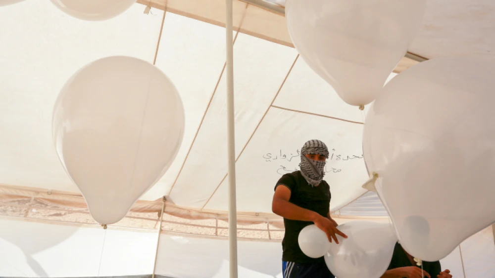Palestinians prepare balloons that will be attached to flammable material during clashes with Israeli security forces on the Gaza-Israeli border on Aug. 10, 2018. Photo by Abed Rahim Khatib/Flash90.
