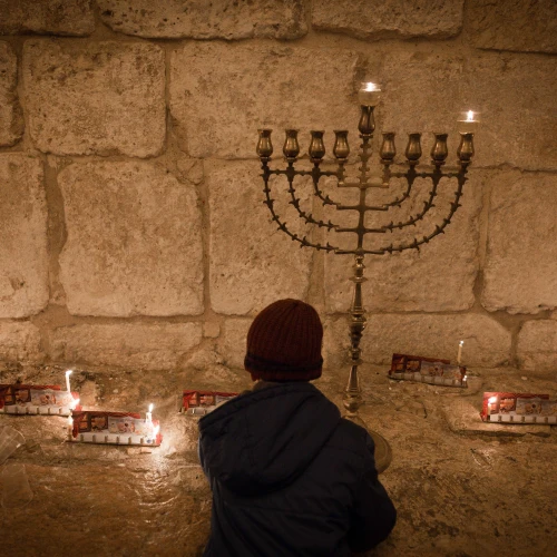 Candles on the first night of the Jewish holiday of Hanukkah, in the Jerusalem neighborhood of Mea Shearim. Hanukkah, also known as the “Festival of Lights,” is an eight-day Jewish holiday commemorating the rededication of the Holy Temple. The festival is observed by the kindling of the lights of a “hanukkiyah,” a nine-branched candelabrum with one additional light being lit on each night of the holiday. Dec. 24, 2016. Photo by Sebi Berens/Flash90.