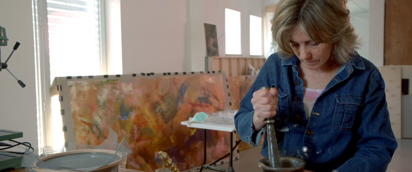 Beverly Barkat grinds material into fragments with a pestle and mortar for her artwork “After the Tribes,” to be exhibited in Rome. Credit: Photo by Tor Ben Mayor.