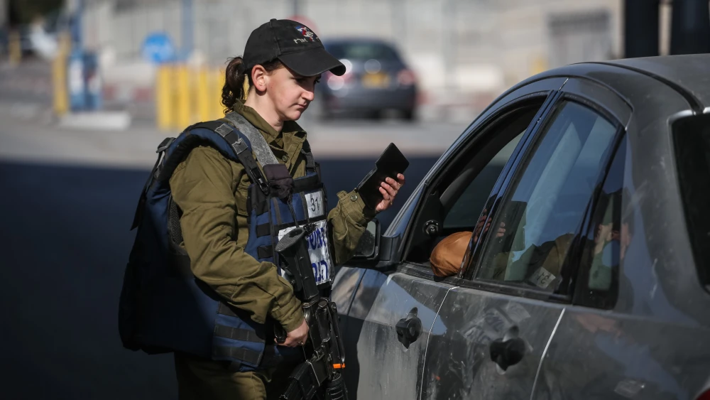 An Israeli soldier from the Erez Battalion in the Military Police checks IDs and Palestinian vehicles at the checkpoint to the Shuafat Refugee Camp in eastern Jerusalem on Dec. 22, 2015. Credit: Hadas Parush/Flash90.