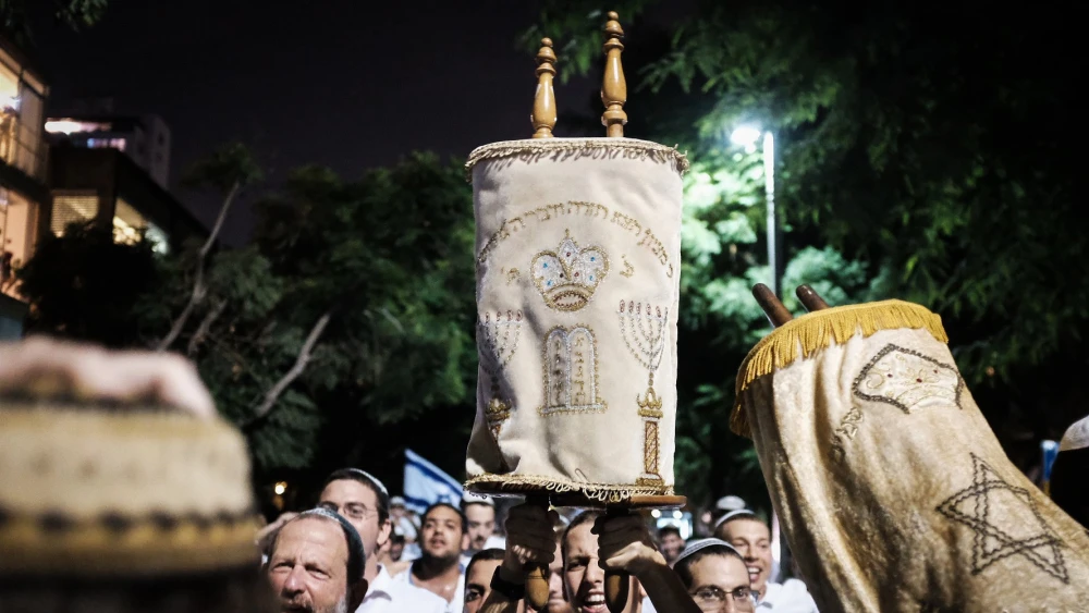 Carrying Torah scrolls as they dance during the celebration of Simchat Torah, marking the end of the annual cycle of the reading of the Torah and starting again, at Rabin Square in Tel Aviv, on Oct. 1, 2018. Photo by Tomer Neuberg/Flash90.