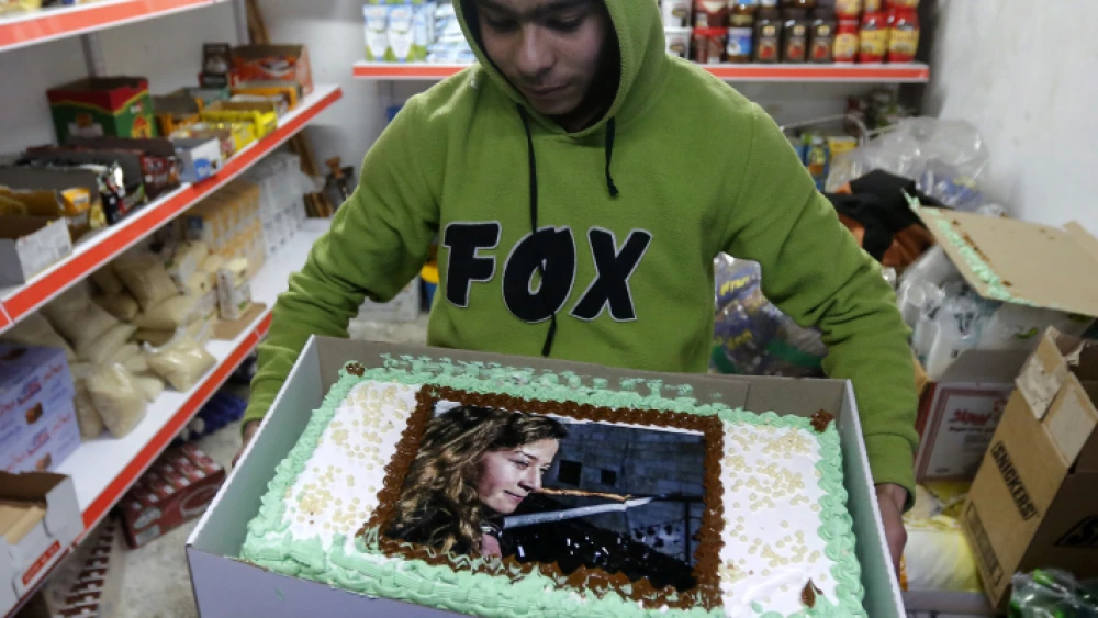 A Palestinian boy holds a cake with a picture of Ahed Tamimi during a protest rally in the city of Hebron on Jan. 30, 2018. Photo by Wisam Hashlamoun/Flash90.