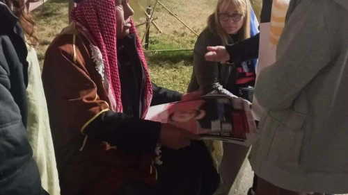 Sheikh Khaled, a resident of Rahat, shows pictures of relatives being held by Hamas in Gaza to supporters and other hostages' families at Tel Aviv's Hostage Square, on Feb. 10, 2024. Photo by Amelie Botbol.