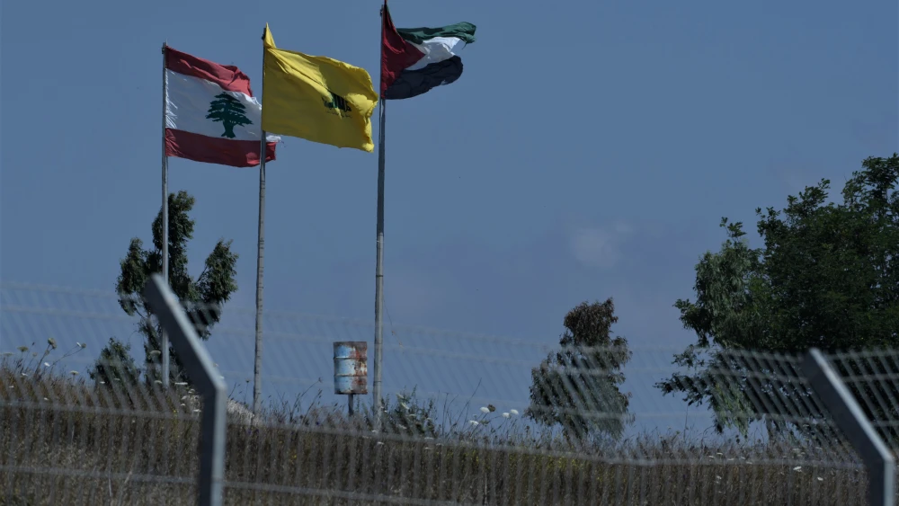 From left, Lebanese, Hezbollah and PLO flags on the border with Israel, July 3, 2022. Photo by Ayal Margolin/Flash90.