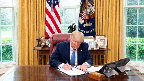 U.S. President Donald Trump signs S. 3503, “A bill to authorize the Secretary of Veterans Affairs to treat certain programs of education converted to distance learning by reason of emergencies and health-related situations in the same manner as programs of education pursued at educational institutions, and for other purposes” on March 21, 2020, in the Oval Office of the White House. Credit: Tia Dufour/The White House.
