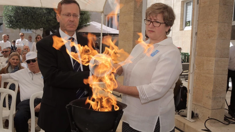 Marnie Fienberg, the daughter-in-law of Joyce Fienberg, who was murdered in the Oct. 27, 2018 Pittsburgh synagogue attack, lights a memorial torch together with Jewish Agency for Israel chairman Isaac Herzog Credit: Noam Sharon.