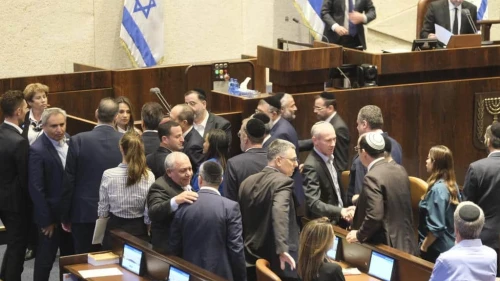 Lawmakers in Jerusalem congratulate one another after Israel's unity government is sworn in, Oct. 12, 2023. Credit: TPS.