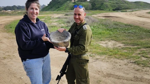 Archaeologist Sarah Tal from the Israel Antiquities Authority and Lt. Col. Yair Amitsur with the grinding mortar. Photo by Ilon Glick.