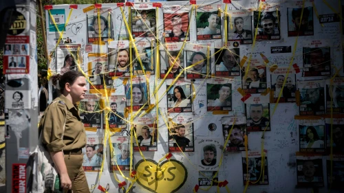 A woman walks past pictures at "Hostage Square" in Tel Aviv of Israelis held hostage by Hamas terrorists in Gaza, June 16, 2024. Photo by Miriam Alster/Flash90.