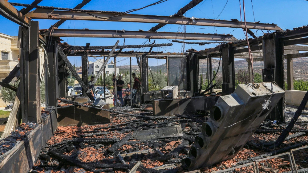 Palestinians inspect a house that was set on fire and spray-painted with graffiti during an attack by a group of extremist Jewish settlers in the village of Osarin on Aug. 23, 2026. Photo by Nasser Ishtayeh/Flash90.