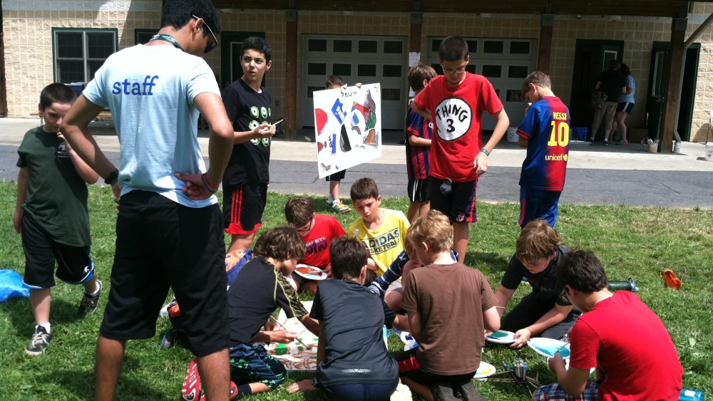 Campers working on a community art project making signs for cabins and buildings around camp, named after and based on cities in Israel. Credit: iCenter for Jewish Education.