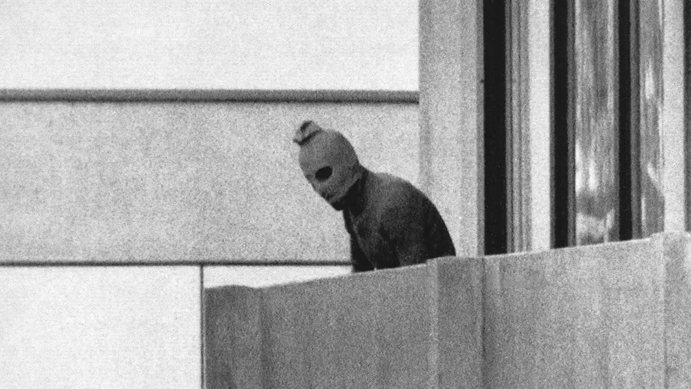 A terrorist appears with a hood over his face on the balcony of the building where members of the Olympics Israeli team were held hostage in Munich, Sept. 5, 1972. Photo credit: AP Photo/Russell McPhedran/Wikimedia Commons